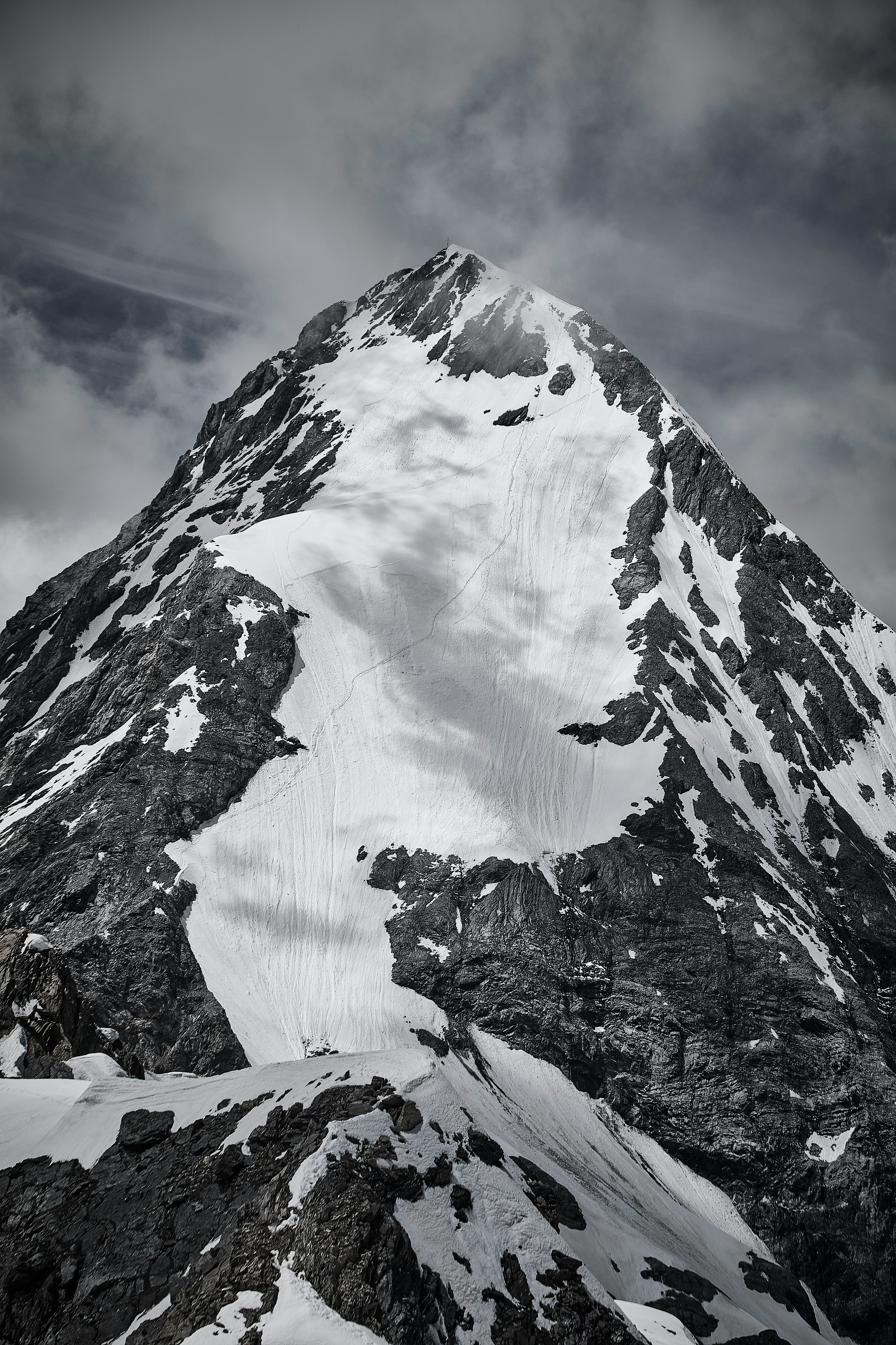 snow covered mountain under cloudy sky during daytime